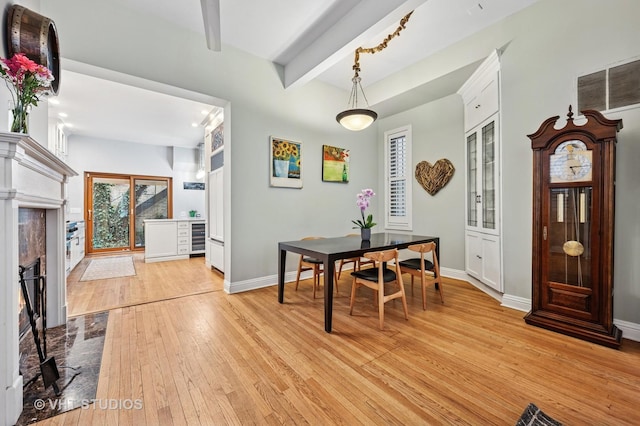 1636 N Cleveland Ave, Chicago, IL 60614 - dining room featuring light wood-style floors, beamed ceiling, beverage cooler, a fireplace with flush hearth, and baseboards