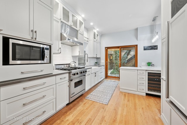 1636 N Cleveland Ave, Chicago, IL 60614 - kitchen with high end appliances, wine cooler, a sink, light wood finished floors, and backsplash