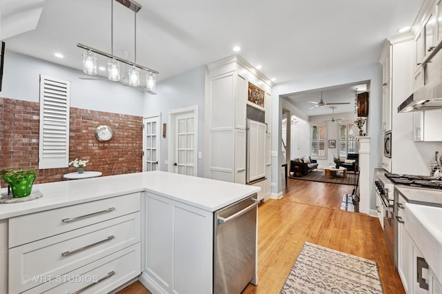 1636 N Cleveland Ave, Chicago, IL 60614 - kitchen featuring a ceiling fan, light wood-style floors, light countertops, white cabinetry, and appliances with stainless steel finishes
