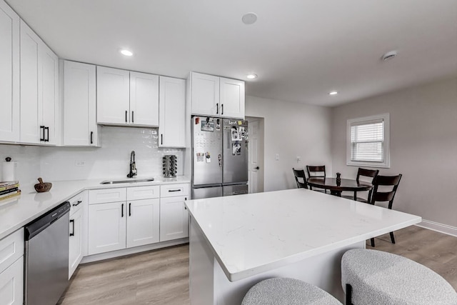 529 Circle Ave, Forest Park, IL 60130 - kitchen with stainless steel appliances, a sink, light wood finished floors, a kitchen bar, and white cabinets