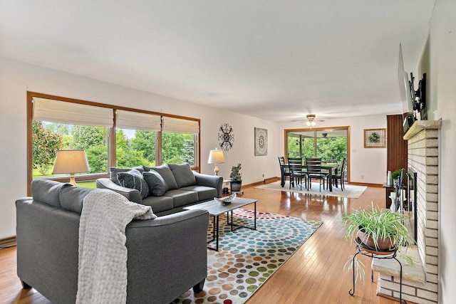115 Thornbrook Rd, Dekalb, IL 60115 - living area with wood-type flooring, a ceiling fan, a brick fireplace, and baseboards