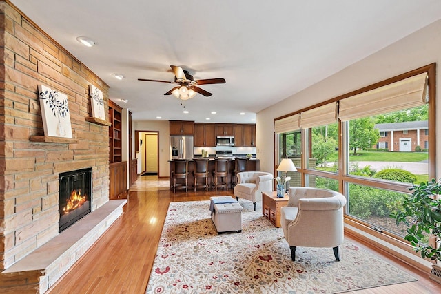 115 Thornbrook Rd, Dekalb, IL 60115 - living area featuring ceiling fan, a stone fireplace, light wood-style flooring, recessed lighting, and built in shelves