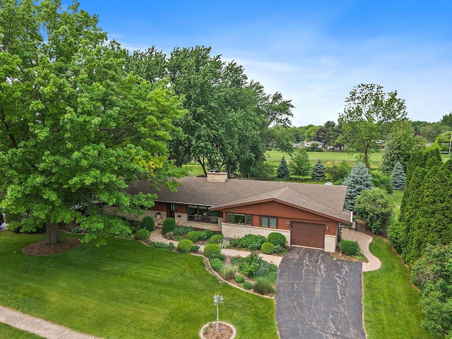 115 Thornbrook Rd, Dekalb, IL 60115 - view of front of home with a garage, asphalt driveway, roof with shingles, a front yard, and view of scattered trees