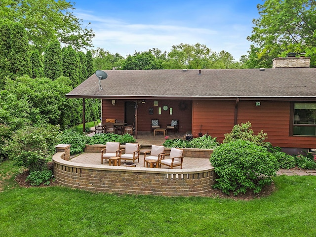 115 Thornbrook Rd, Dekalb, IL 60115 - rear view of house featuring a patio, a lawn, a chimney, and roof with shingles