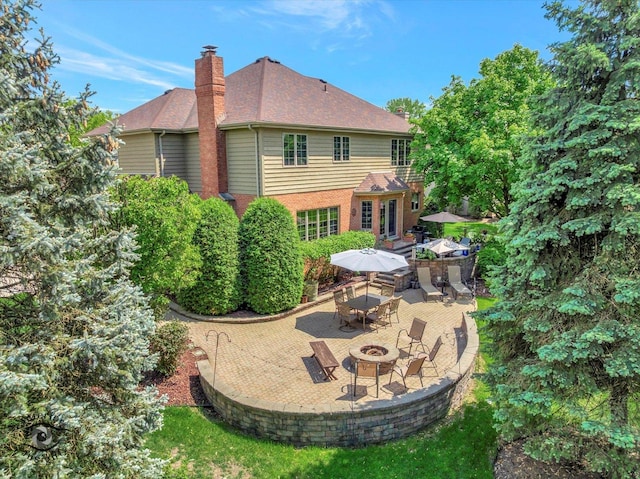 21048 Tall Grass Dr, Mokena, IL 60448 - rear view of house featuring a fire pit, a chimney, a patio, and outdoor dining area