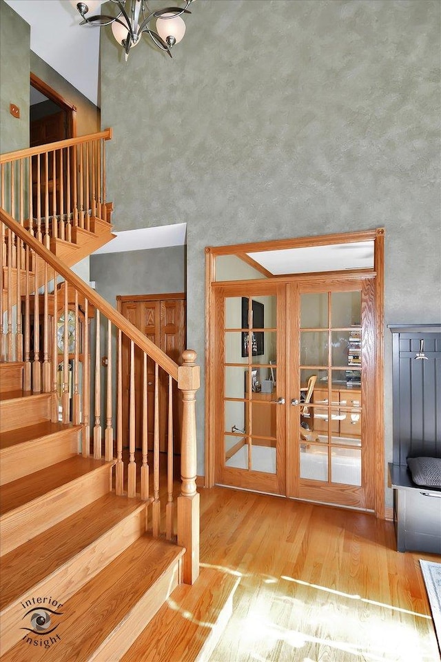 21048 Tall Grass Dr, Mokena, IL 60448 - stairway featuring wood finished floors, a towering ceiling, and a chandelier