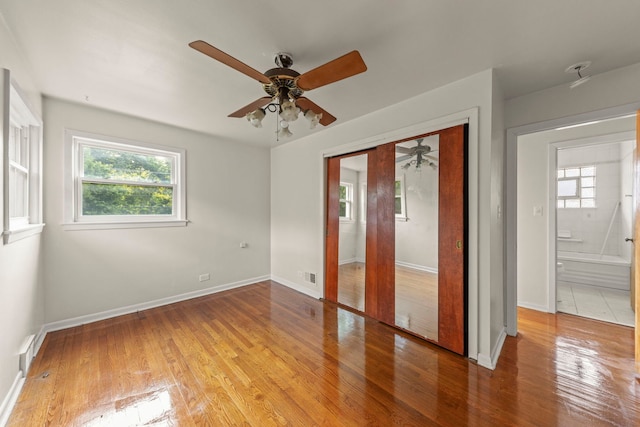 4537 Fishermans Ter, Lyons, IL 60534 - unfurnished bedroom featuring multiple windows, light wood-type flooring, a closet, and ceiling fan