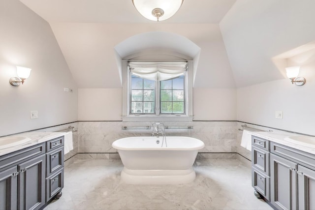 724 Becker Rd, Glenview, IL 60025 - bathroom with vanity, lofted ceiling, a freestanding bath, tile walls, and a wainscoted wall