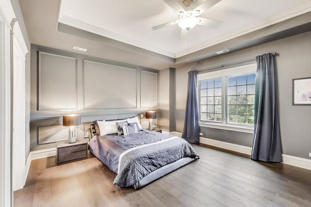 724 Becker Rd, Glenview, IL 60025 - bedroom with hardwood / wood-style floors, baseboards, crown molding, a tray ceiling, and ceiling fan
