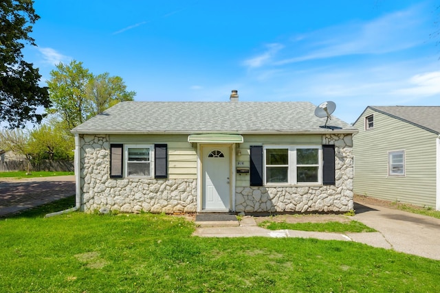 916 5th Ave, Aurora, IL 60505 - bungalow-style house with stone siding, roof with shingles, a front yard, and a chimney