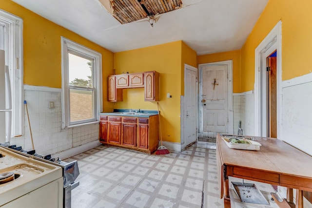 2227 W 21st St, Chicago, IL 60608 - kitchen with light floors, a wainscoted wall, white electric range, and a sink