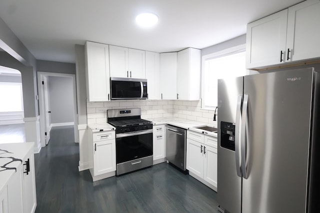 10817 S Eberhart Ave, Chicago, IL 60628 - kitchen with appliances with stainless steel finishes, a sink, dark wood-style floors, decorative backsplash, and white cabinetry