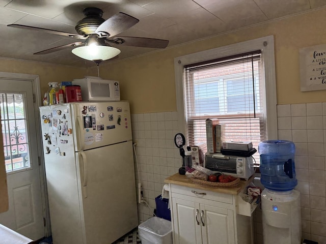 11247 S S Ave L, Chicago, IL 60617 - kitchen featuring white appliances, tile walls, plenty of natural light, a ceiling fan, and white cabinetry