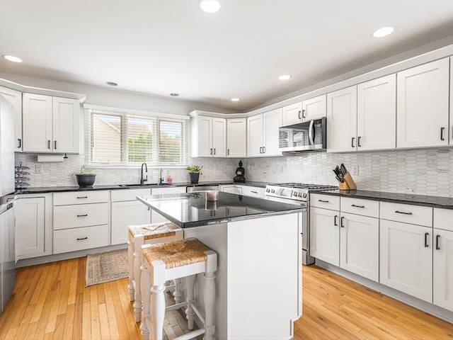 11546 Ridgecrest Dr, Roscoe, IL 61073 - kitchen with stainless steel appliances, white cabinetry, tasteful backsplash, light wood-type flooring, and recessed lighting