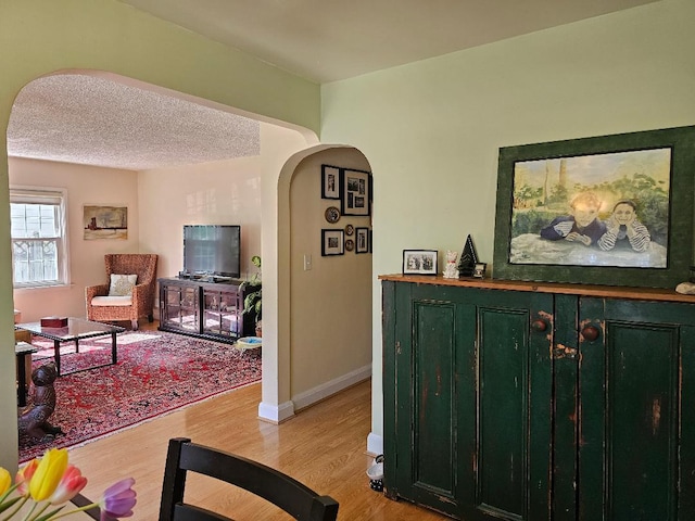 213 W Park Ave, Wheaton, IL 60189 - living room with arched walkways, light wood-style floors, and baseboards
