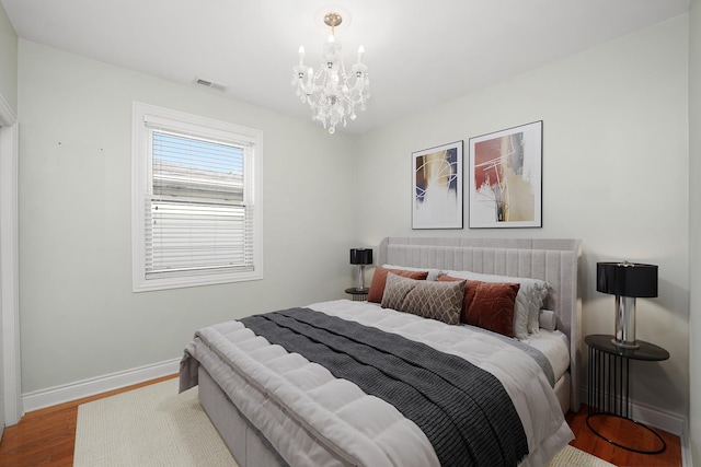 5151 W Fletcher St, Chicago, IL 60641 - bedroom with baseboards, wood finished floors, and a chandelier