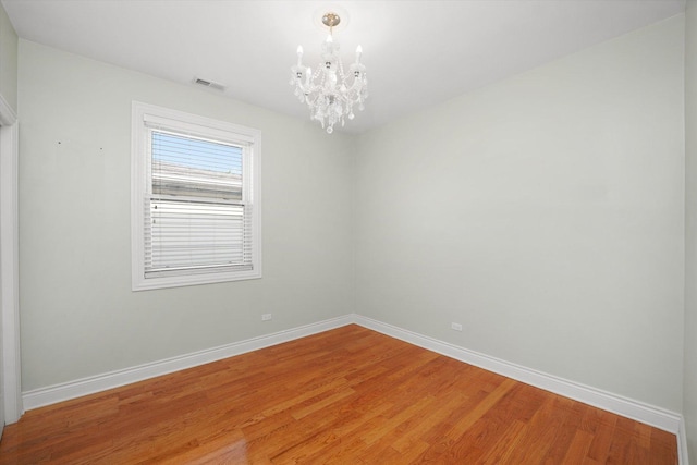 5151 W Fletcher St, Chicago, IL 60641 - unfurnished room with a chandelier, baseboards, and light wood-style flooring