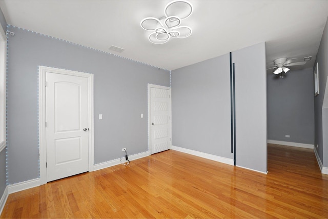 5151 W Fletcher St, Chicago, IL 60641 - unfurnished bedroom featuring light wood finished floors, baseboards, and a chandelier