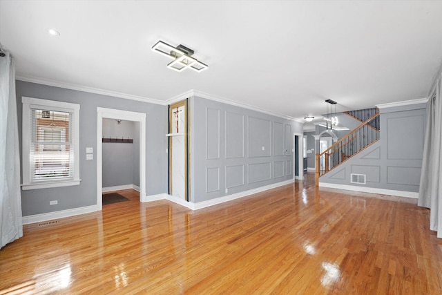 5151 W Fletcher St, Chicago, IL 60641 - unfurnished living room with stairs, a decorative wall, light wood finished floors, ornamental molding, and baseboards
