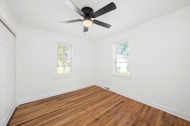 345 W Joe Orr Rd, Chicago Heights, IL 60411 - unfurnished bedroom with a closet, multiple windows, wood finished floors, and a ceiling fan