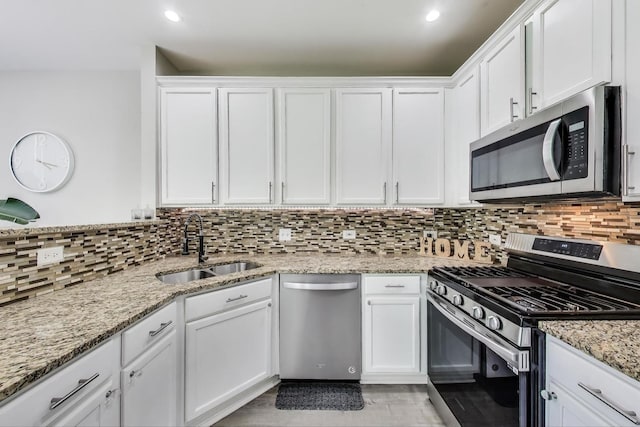 2253 Sunrise Cir, Aurora, IL 60503 - kitchen with stainless steel appliances, a sink, white cabinetry, decorative backsplash, and light stone counters