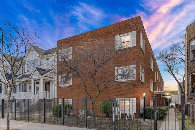 4730 N Hermitage Ave Unit 2F, Chicago, IL 60640 - view of home's exterior with a fenced front yard, brick siding, and a gate