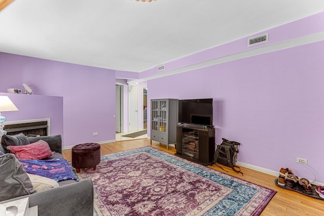 4730 N Hermitage Ave Unit 2F, Chicago, IL 60640 - living room featuring a fireplace, wood finished floors, and baseboards