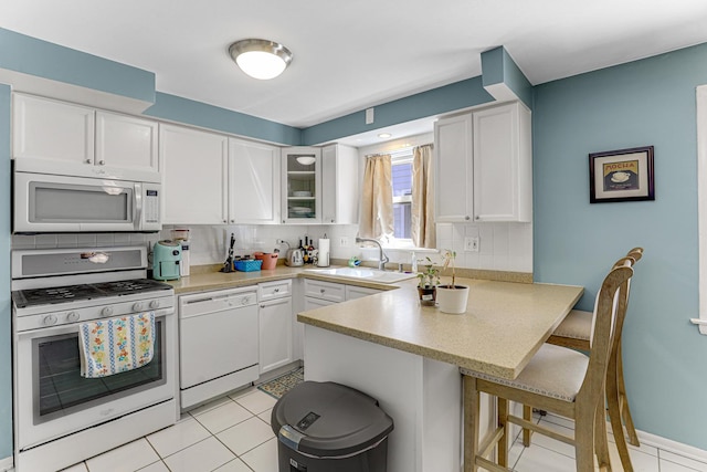 4730 N Hermitage Ave Unit 2F, Chicago, IL 60640 - kitchen featuring white appliances, a sink, a peninsula, tasteful backsplash, and white cabinets