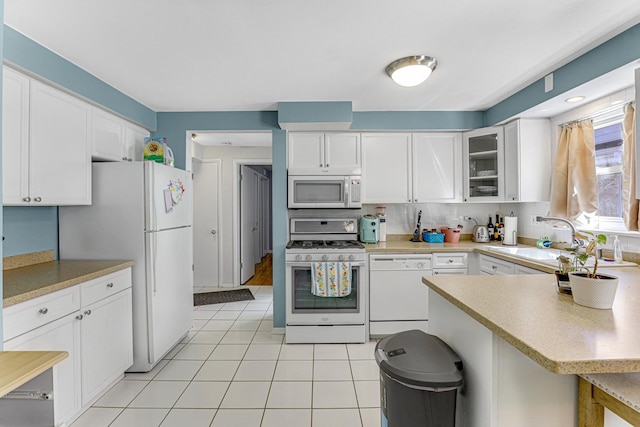 4730 N Hermitage Ave Unit 2F, Chicago, IL 60640 - kitchen with white appliances, white cabinetry, a sink, and glass insert cabinets