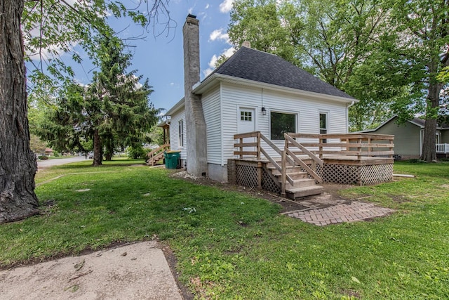 324 W Sumner St, Streator, IL 61364 - rear view of property featuring a deck, a chimney, a lawn, and a shingled roof