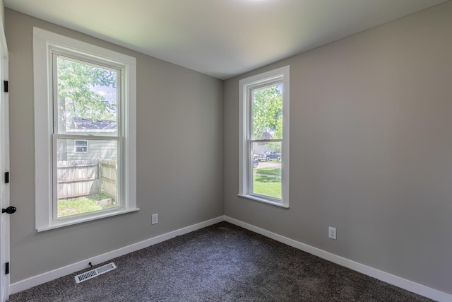324 W Sumner St, Streator, IL 61364 - empty room featuring dark colored carpet and baseboards
