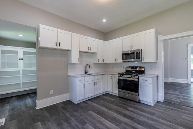 324 W Sumner St, Streator, IL 61364 - kitchen with appliances with stainless steel finishes, a sink, light countertops, white cabinets, and dark wood-style flooring