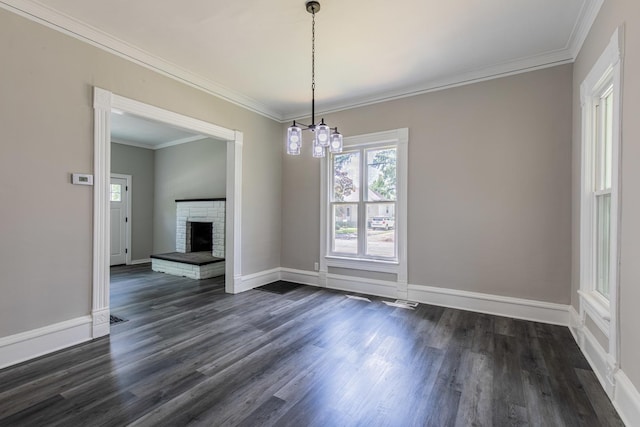 324 W Sumner St, Streator, IL 61364 - unfurnished dining area featuring dark wood-style flooring, ornamental molding, baseboards, a brick fireplace, and a chandelier