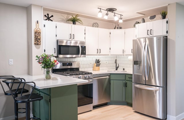 55 S Elmwood Ave, Palatine, IL 60074 - kitchen with appliances with stainless steel finishes, a sink, a peninsula, light countertops, and backsplash