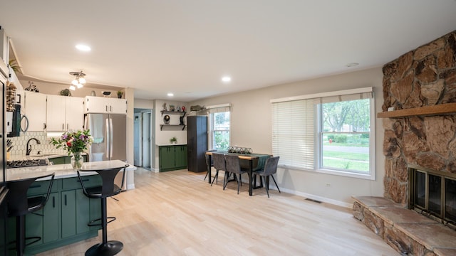 55 S Elmwood Ave, Palatine, IL 60074 - kitchen with stainless steel fridge with ice dispenser, light countertops, decorative backsplash, a kitchen breakfast bar, and white cabinetry