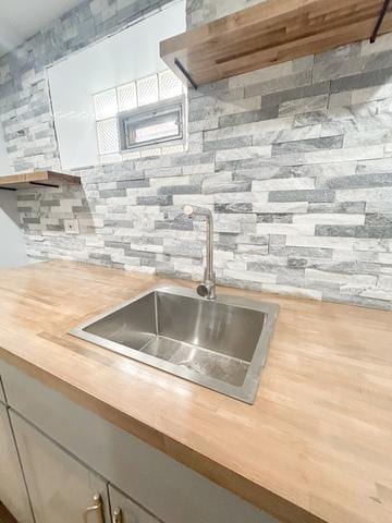 9536 S Woodlawn Ave, Chicago, IL 60628 - kitchen view of butcher block countertops, a sink, and tasteful backsplash