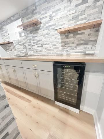 9536 S Woodlawn Ave, Chicago, IL 60628 - indoor bar featuring wine cooler, light wood finished floors, and tasteful backsplash