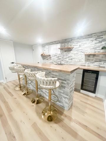 9536 S Woodlawn Ave, Chicago, IL 60628 - indoor wet bar featuring light wood-style floors, beverage cooler, and backsplash