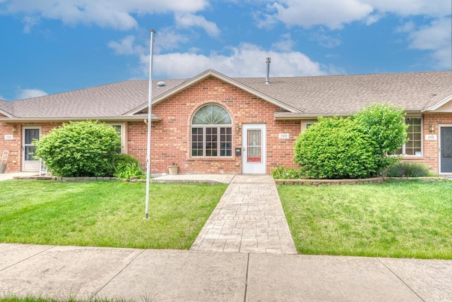 262 Jennifer Ln Unit 262, Wilmington, IL 60481 - view of front of home featuring brick siding, roof with shingles, and a front yard