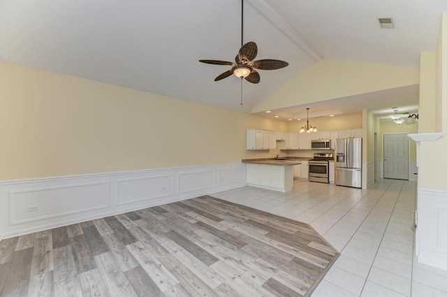 262 Jennifer Ln Unit 262, Wilmington, IL 60481 - kitchen with stainless steel appliances, beam ceiling, open floor plan, a ceiling fan, and a peninsula