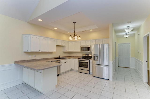 262 Jennifer Ln Unit 262, Wilmington, IL 60481 - kitchen with appliances with stainless steel finishes, a sink, a peninsula, a chandelier, and a wainscoted wall
