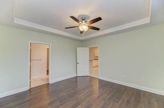 262 Jennifer Ln Unit 262, Wilmington, IL 60481 - unfurnished bedroom featuring a raised ceiling, dark wood finished floors, baseboards, and a ceiling fan