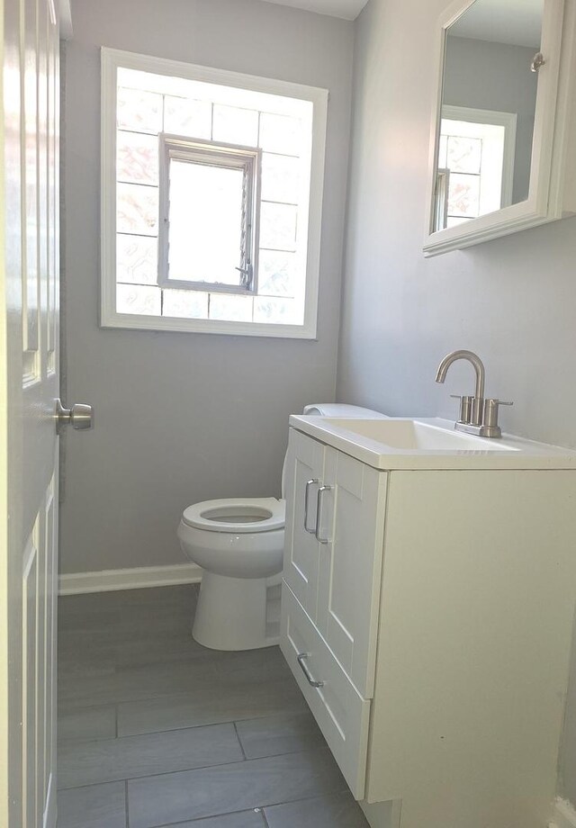 8732 S Laflin St, Chicago, IL 60620 - half bathroom with healthy amount of natural light, toilet, vanity, and baseboards