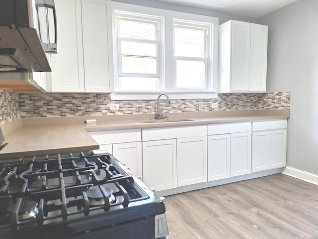 8732 S Laflin St, Chicago, IL 60620 - kitchen with a sink, white cabinets, light countertops, light wood finished floors, and exhaust hood