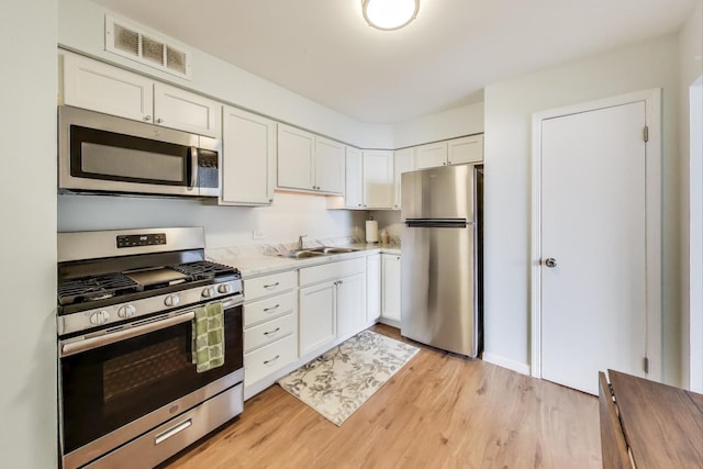 6325 N Sheridan Rd Unit 608, Chicago, IL 60660 - kitchen with appliances with stainless steel finishes, light countertops, light wood finished floors, and white cabinetry