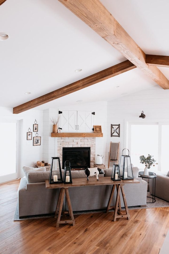 281 Snipe Hollow Rd N, Elizabeth, IL 61028 - living area featuring healthy amount of natural light, beamed ceiling, a glass covered fireplace, and light wood-style flooring