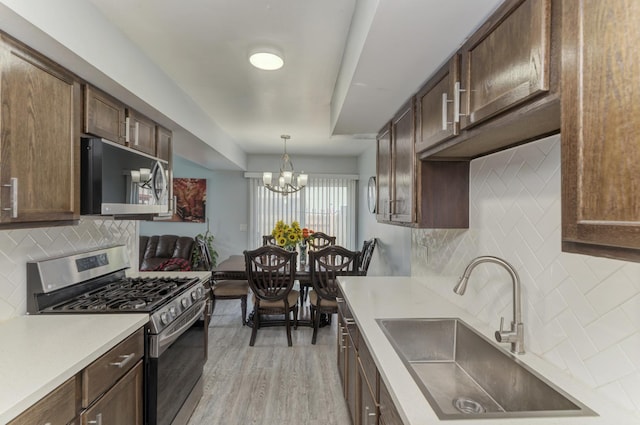 7 Fernwood Dr Unit Q, Bolingbrook, IL 60440 - kitchen featuring stainless steel appliances, a sink, tasteful backsplash, and a chandelier