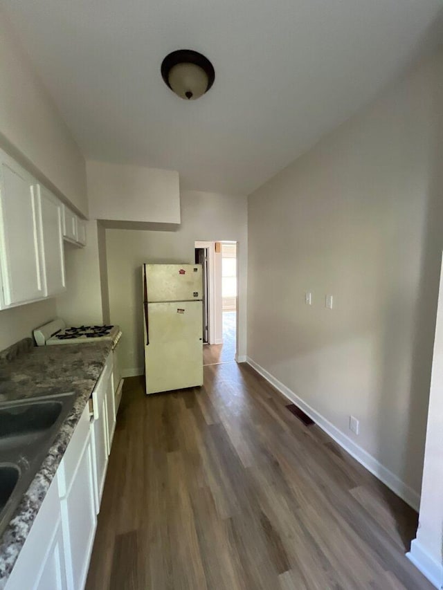 363 E Hickory St, Kankakee, IL 60901 - kitchen with freestanding refrigerator, white cabinets, dark wood-style flooring, light stone countertops, and stovetop