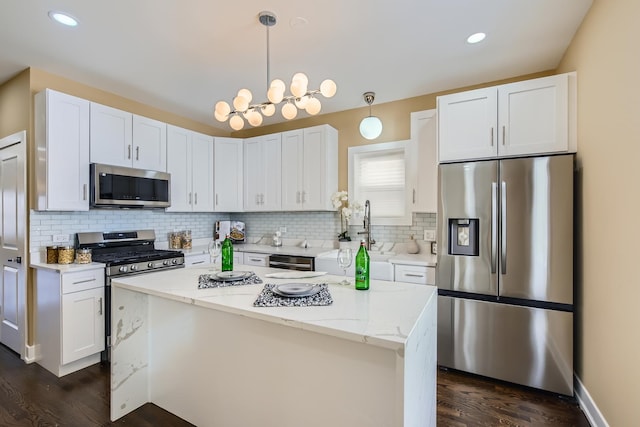 8431 S Crandon Ave, Chicago, IL 60617 - kitchen featuring stainless steel appliances, dark wood finished floors, decorative backsplash, white cabinets, and decorative light fixtures