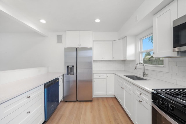 163 Queenswood Rd, Bolingbrook, IL 60440 - kitchen with appliances with stainless steel finishes, a sink, light wood-style flooring, white cabinets, and light countertops